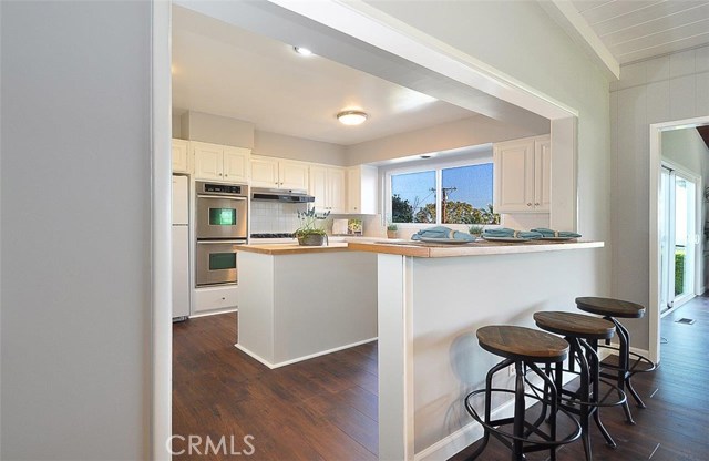 Kitchen with high bar seating, island and stainless appliances.  Beautiful view from kitchen window.