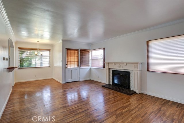 Oak hardwood floor in the dining and living room with a wood burning fireplace.  Note the natural wood window frames.