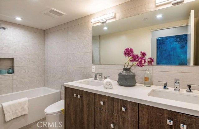 This full bathroom with double sinks serves the basement level