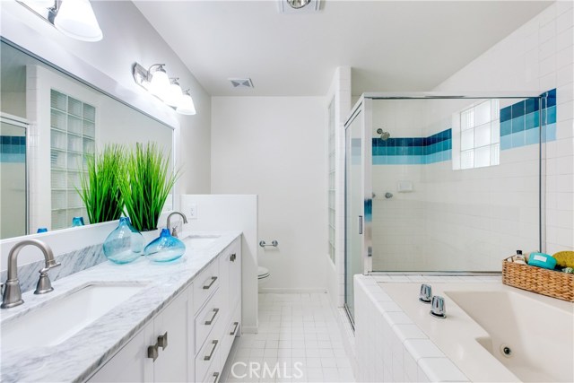 The master bath includes a large walk in shower, brand new custom vanity, new mirrors, and a soaking tub