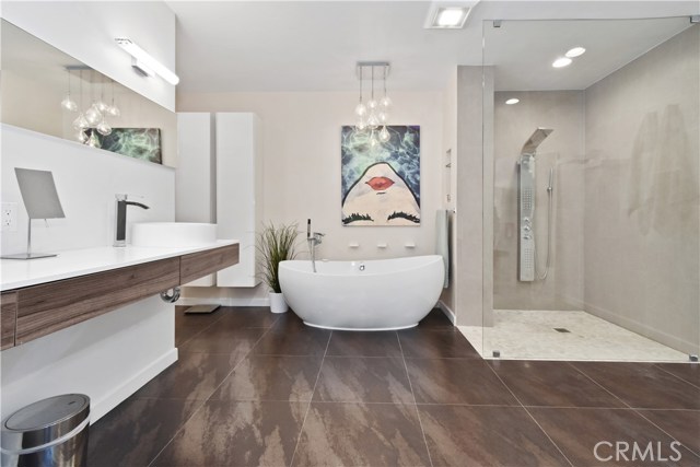 Elegant bath with dual sinks, soaking tub, spacious shower, private toilet with bidet, and wonderful storage.