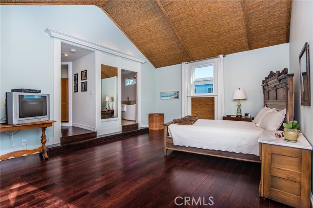 Very large upstairs bedroom with hardwood floors and a vaulted ceiling.