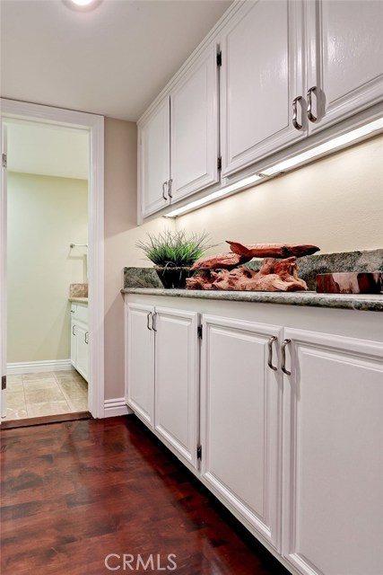 Custom built-in storage with 'Costa Smeralda' granite line the hallway leading to the powder room.