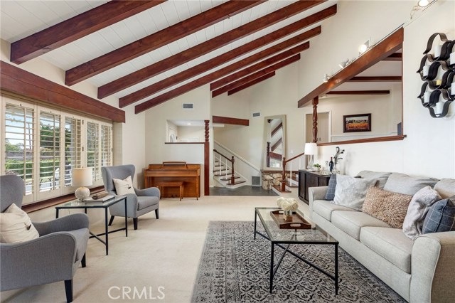 The ocean view living room brings gorgeous golden sunsets in a picturesque setting. With a large warm fireplace, exposed rich wood beam ceiling, and the open style space adds to the highlights of the home.