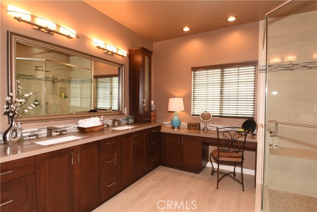 Luxurious fully remodeled master bathroom is large, with double sinks, Caesarstone counters, plank tile flooring, and terrific vanity area.  Huge walk in shower with rainfall shower head and and regular shower head too!