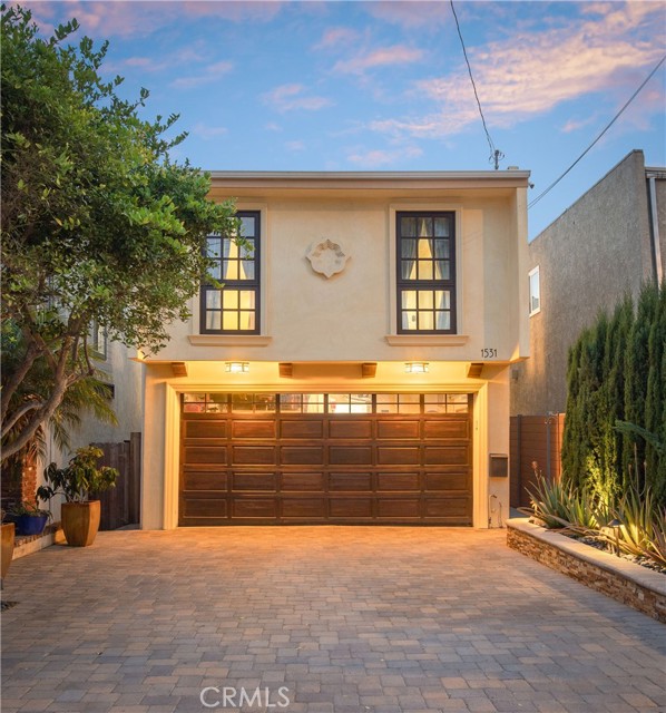 The exterior of the home has been beautifully updated to accentuate the home's Mediterranean style with the curated soft tone of the smooth stucco finish, hand-selected paving stones for the driveway and walkways, outdoor lighting to compliment the design, and newer planters and sprinkler system.