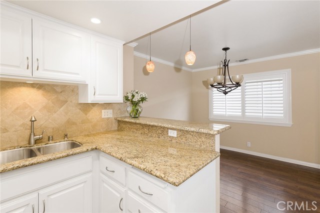 Kitchen with beautiful granite counter tops , breakfast bar and kitchen nook fir eating area.