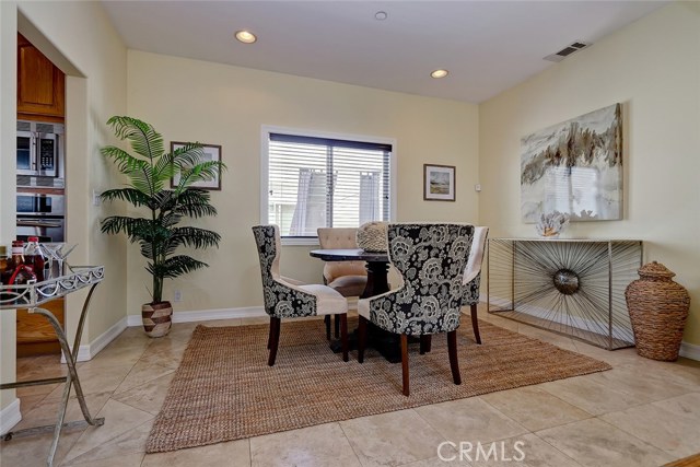 Formal dining area with travertine floors and recessed lighting.