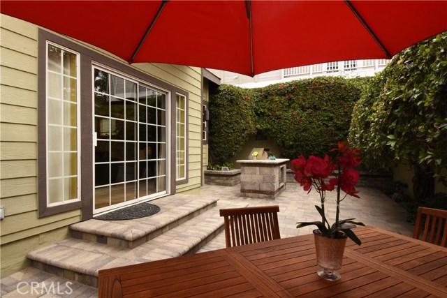 Adorable low maintenance rear yard has pretty paver stones and built-in BBQ area.  Nice landscaping.  Sliding door opens onto the family room and kitchen area.
