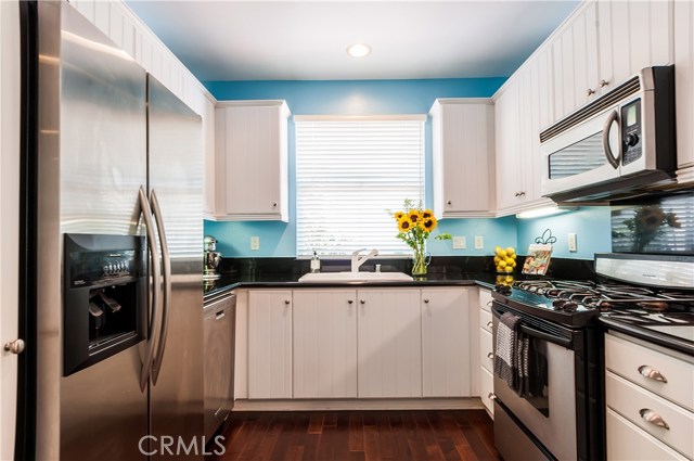 Stylish kitchen includes white cabinets, granite countertops, and stainless appliances.