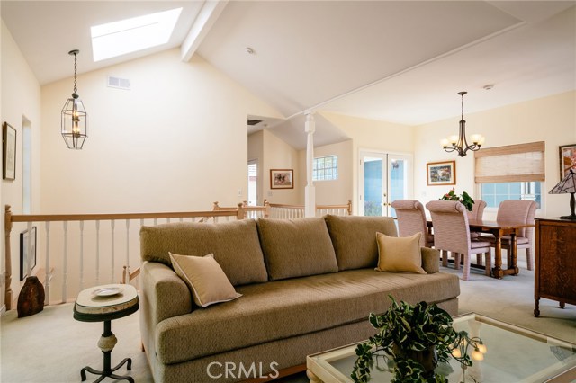 Looking back toward dining area from living room. Notice large skylight letting the sun shine in and the high ceilings