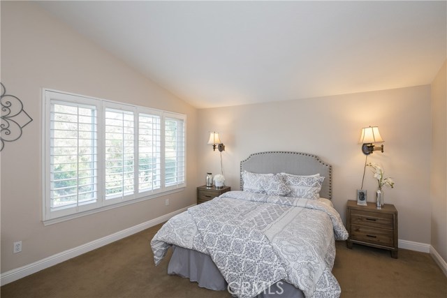 Masters bedroom with plantation shutters & beautiful view of trees.