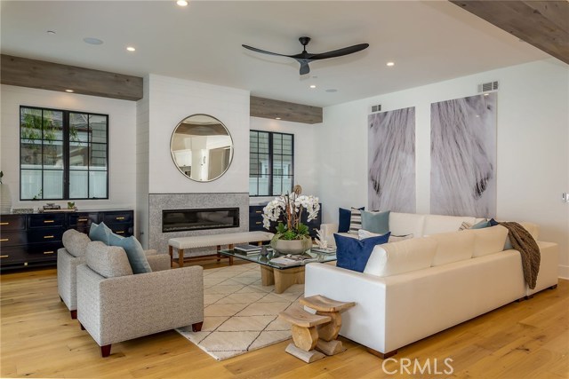 Stylish family room with beams, fireplace, fan