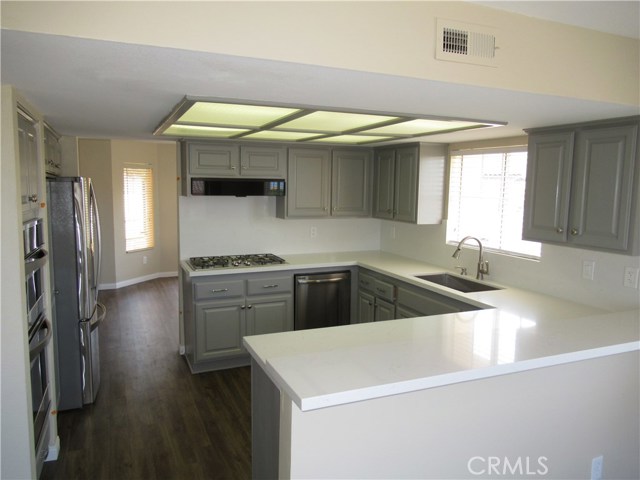 Kitchen Pic #2 - New GE 5 burner stove top, New GE Dishwasher, New Stainless Steel Sink, New Quartz Counter Tops, New Vinyl Wood Flooring. Additional Kitchen Appliances include Kenmore Convection Oven and Microwave and Refrigerated Wine Rack.Kitchen Cabinets have been refurbished and painted.