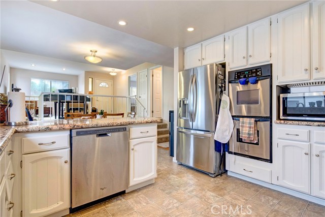 Updated kitchen with granite countertops and all stainless steel appliances looking out in to the dining and living room areas!