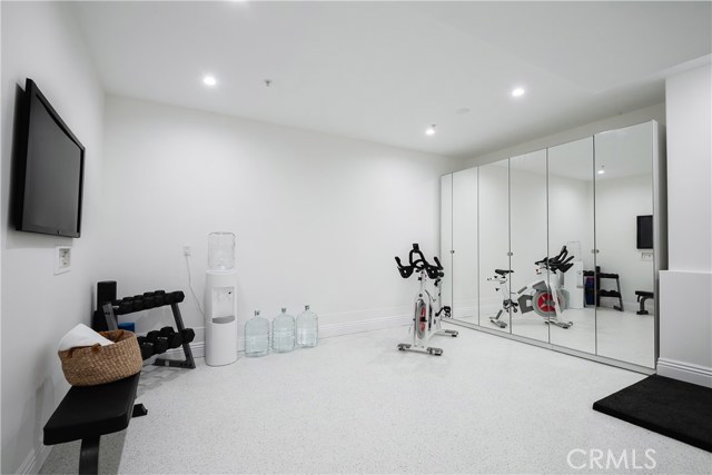 Gym boasts epoxy floors, recessed lighting, mirrored floor to ceiling cabinetry, cable/internet hookups, and multiple outlets plus USB charging hub.