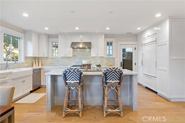 The show-stopping kitchen is upgraded to perfection with custom cabinetry and island by His Life, a built-in Sub-Zero refrigerator, Wolf 6-burner range, countertops by Neolith, and thoughtful conveniences where no detail has been spared.