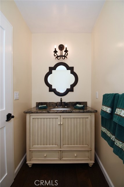 Powder room with new cabinet, new counter, new mirror, new lights, new doors and hardware and new real wood floor.