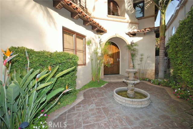 Front courtyard leads to dual arched hand-carved mahogany front doors
