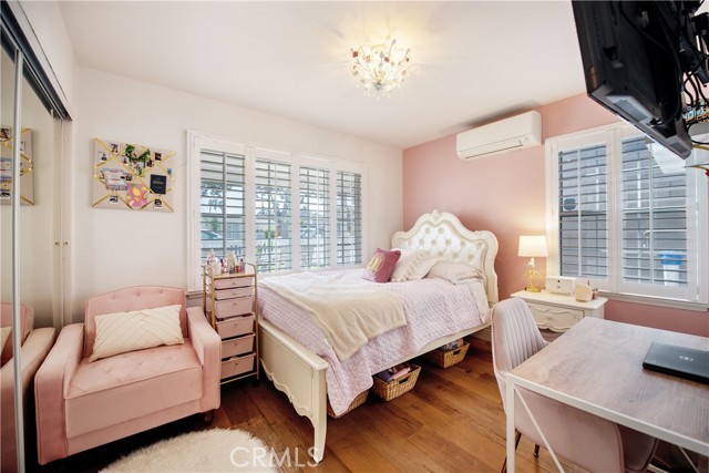 Front guest bedroom with large windows, wide plank hardwood floors, plantation  shutters, a/c, mirrored closets and more.