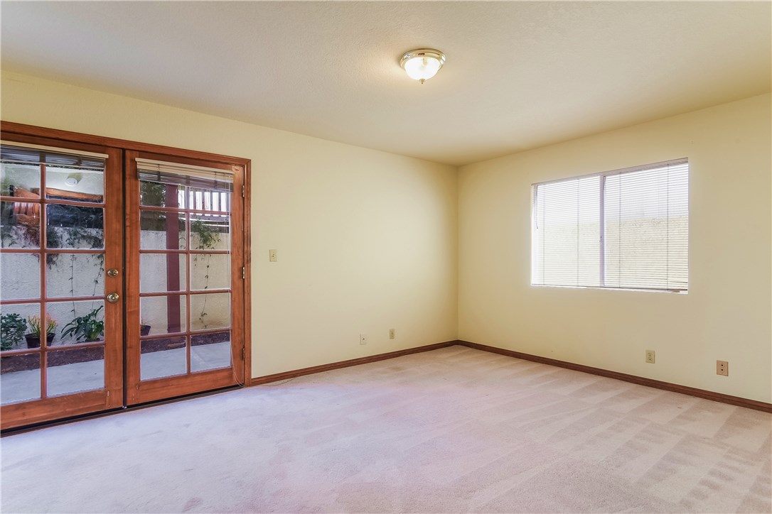 The spacious second lower level bedroom is located at the rear of the home and opens onto the rear patio yard through the wooden double doors.