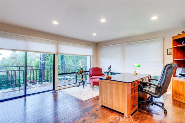 On the lower level is another bedroom also being utilized as a home office. This room also includes a private balcony and oversized windows from lots of light