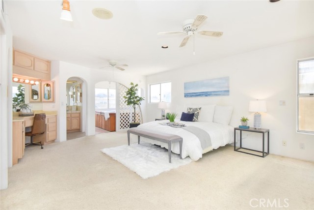 Master ensuite bedroom, with vanity station and sink.  Middle arched doorway goes to the ensuite bathroom.  Larger archway goes to the Spa room with access to the Roof Top with Ocean views.