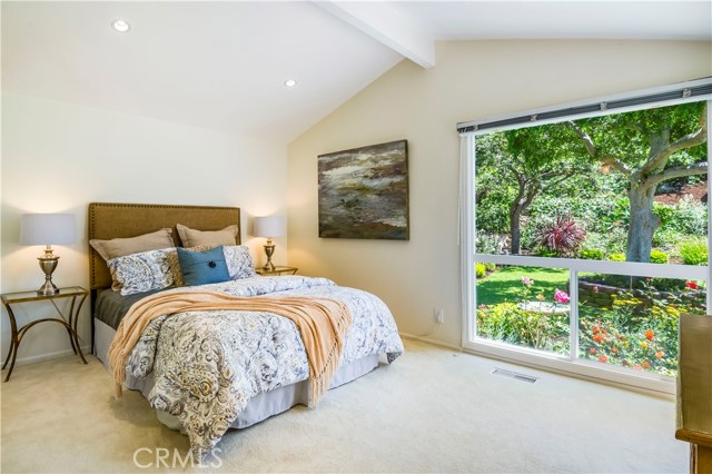 Bedroom with high ceilings and large windows to take in the view of the lushly landscaped yard. Door from bedroom to yard for easy access.