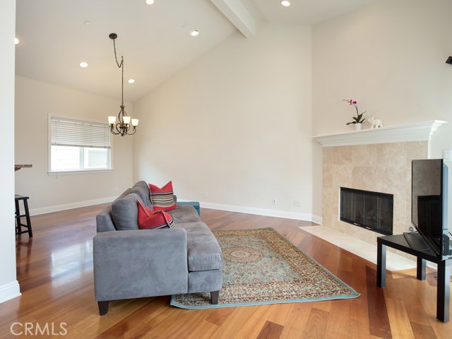 Living room welcomes a stylish fireplace with vaulted ceilings and recessed lighting.