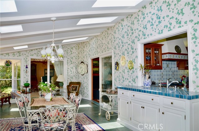 View of the Sunroom which beams with light throughout the day. Current owner used this area for formal dining and entertaining capturing the views of the gardens and City lights at night.