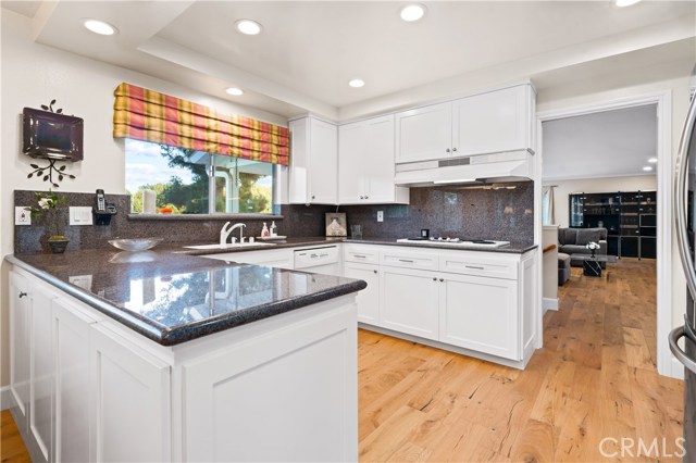 Open concept kitchen with views of lush landscape.