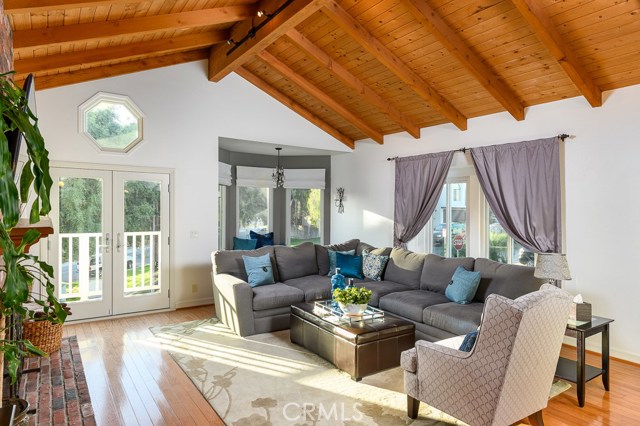 Light and bright living room with vaulted ceilings, fireplace, reading nook, and balcony overlooking the parkette.