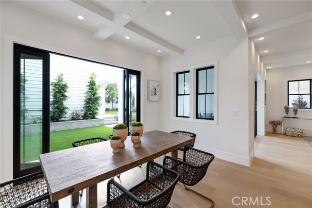 Gorgeous contrasting glass paneled doors welcome the indoors into the beautifully landscaped backyard