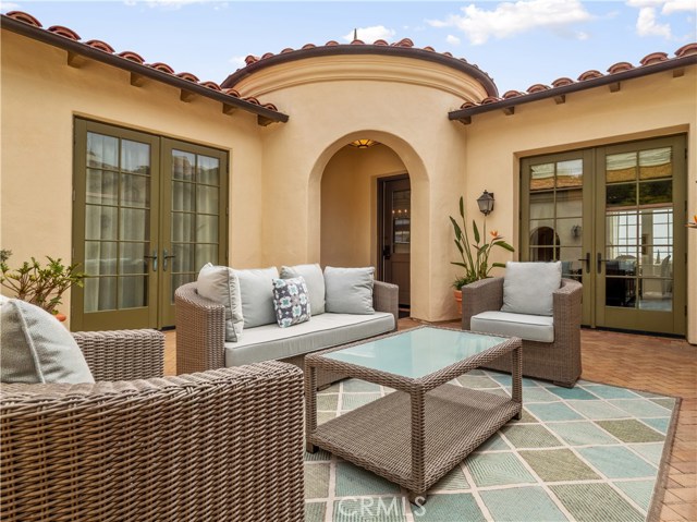 Patio courtyard can be accessed from the den (left), the front door (in the archway) and the kitchen (right).