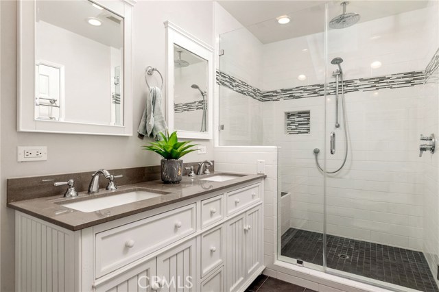 The primary suite's bathroom is newly remodeled in a gorgeous contemporary style with neutral tones and efficient use of space. The extra large shower features dual shower heads with a relaxing and soothing rain head shower feature.