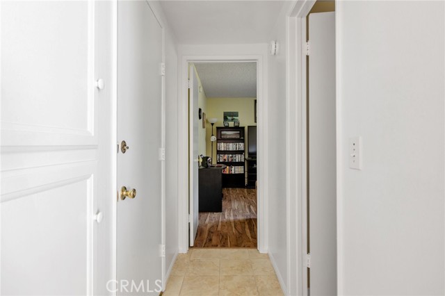 Hallway leading to entry level bedroom straight ahead.  Garage door on left and bathroom door on right.
