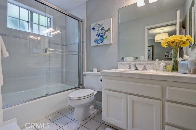 Guest bathroom features combo shower/tub plus plenty of storage.