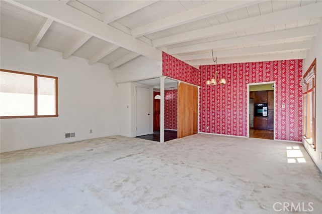 Living room looking at entry, east side window, into dining room and entrance to kitchen.