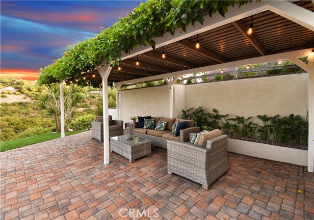 Covered backyard seating area with string lights and views