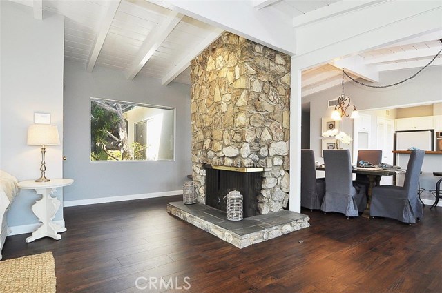 View of Central Stone Fireplace in Living Room looking towards the dining room and Kitchen.