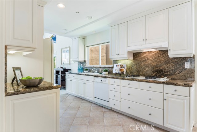 Kitchen with granite counter tops and granite backsplash