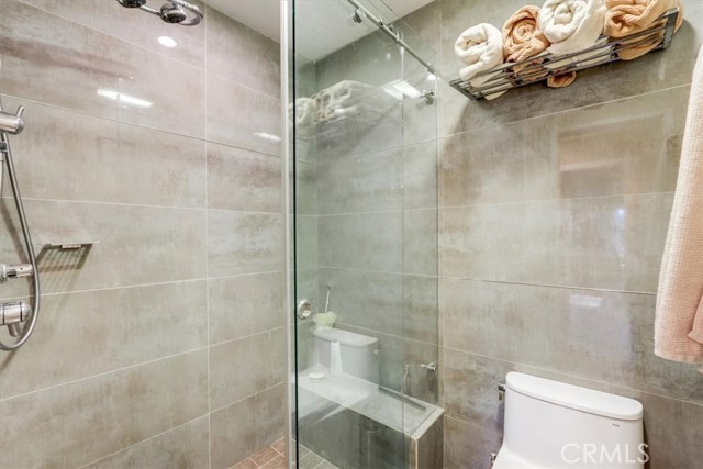 Primary shower with ceramic tile, two headed shower and body sprayer w/charming glass barn door opening....feels like your own personal spa day!