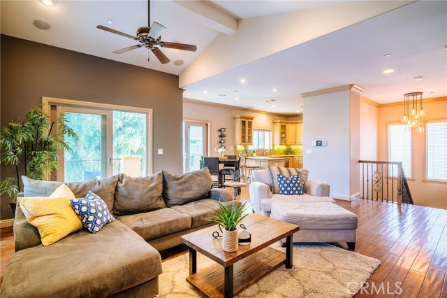 A dramatic yet comfortable setting - the living room is a space with vaulted ceilings, hardwood floors, recessed lighting, fireplace, and more.