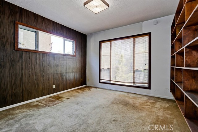 Another downstairs bedroom with back yard area visible through the windows.
