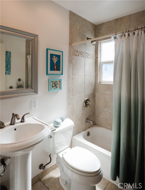 Hallway Bath with pedestal sink and tiled bath