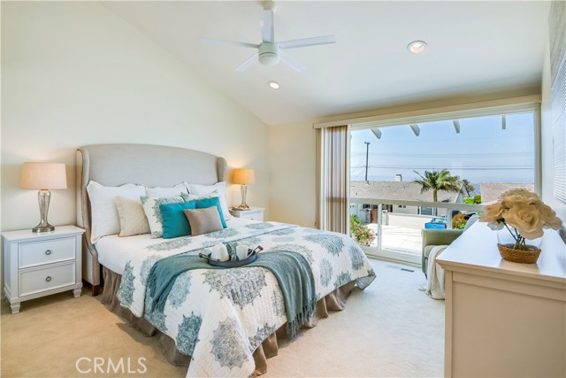 Master bedroom with view, ceiling fan and recessed lighting.