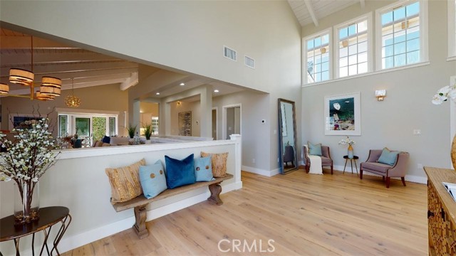 another view of the foyer and grand entrance. wide blank wood floors, high ceilings and an abundance of natural light