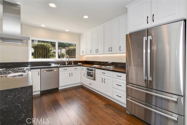 Another perspective on the kitchen which has extensive black quartz counters