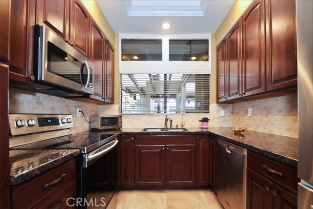 Remodeled kitchen with new range and microwave in 2017. Granite counter tops, tile backsplash and tile floor.