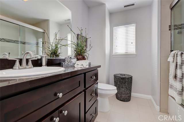 Guest bathroom with combo shower/tub, tile floors and granite countertops.